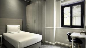 a bedroom with a bed and a desk and a window at The Ancestry Suites in Wasig +25 photos
