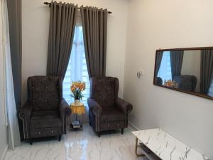 a living room with two chairs and a mirror at Sri Biah Homestay in Kuala Berang