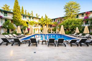 a swimming pool with chairs and umbrellas next to a hotel at Casa Blue Hotel All Inclusive in Bodrum City