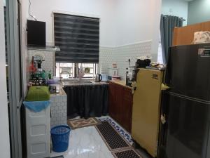 a kitchen with a refrigerator and a sink at Sri Biah Homestay in Kuala Berang