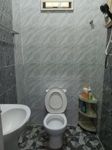 a bathroom with a white toilet and a sink at Sri Biah Homestay in Kuala Berang +9 photos