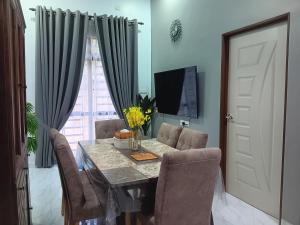 a dining room with a table and chairs and a television at Sri Biah Homestay in Kuala Berang