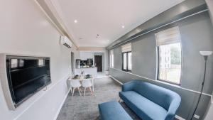 a living room with a blue couch and a table at The Ancestry Suites in Wasig