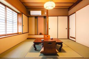 a room with a table and a laptop on it at Osaka Ryokan Kuramoto in Osaka