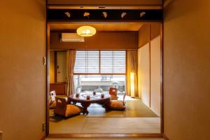 a living room with a table and chairs and a window at Osaka Ryokan Kuramoto in Osaka