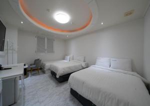 a hotel room with two beds and a desk and a room at Hasen Dangjin Tourist Hotel in Dangjin