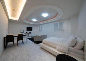 a bedroom with a bed and a table and chairs at Hasen Dangjin Tourist Hotel in Dangjin