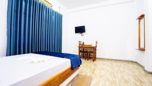 a bedroom with a bed and a blue curtain at OKI Nature Resort in Dambulla