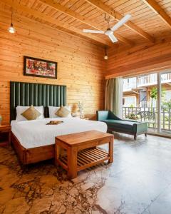 a bedroom with a bed and a couch and a table at Dallas Beach Resorts Ashvem Beach in Mandrem +98 photos
