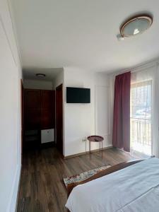 a bedroom with a bed and a table and a window at Casa TeoDora Caciulata in Căciulata