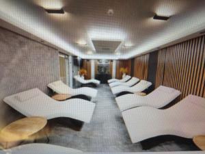 a row of white chairs in a room at Great Choice Apartment in Chernomorets +19 photos