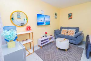 a living room with a blue couch and a tv at A&M Luxury bnbs in Nairobi