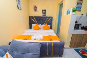 a bedroom with a bed with orange and yellow pillows at A&M Luxury bnbs in Nairobi