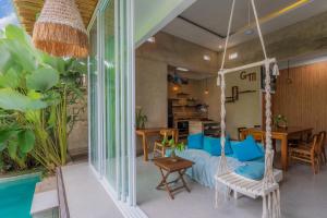 a room with a swinging bed and a dining room at Gemello Bali Villa in Keramas