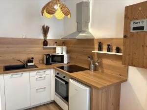 a kitchen with white cabinets and a stove top oven at Little Wild - Centre Ville in Saverne