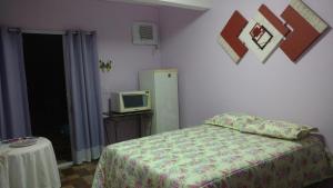 Un dormitorio pequeño con una cama y un televisor. en Suites Canto dos Passaros, en Ilhabela 40 fotos más