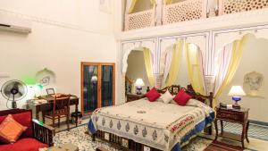 a bedroom with a bed with red pillows at Dera Mandawa in Jaipur