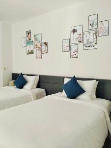 two beds in a room with pictures on the wall at Bin Bin Coastar Villa Hồ Tràm in Ho Tram +23 photos