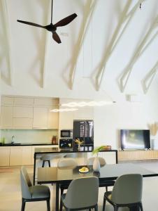 a kitchen with a dining table and a ceiling fan at Bin Bin Coastar Villa Hồ Tràm in Ho Tram