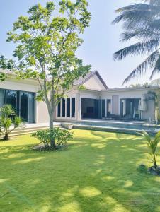a house with a green yard in front of it at Bin Bin Coastar Villa Hồ Tràm in Ho Tram