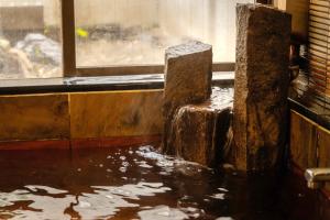 a dirty room with a pool of water next to a window at Osaka Ryokan Kuramoto in Osaka +21 photos