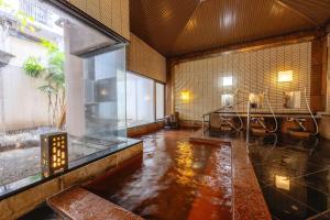 a large room with a pool of water in a bathroom at Osaka Ryokan Kuramoto in Osaka