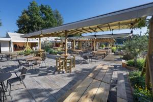 a patio with tables and chairs and awnings at Hostel Hluboká in Hluboká nad Vltavou +3 photos