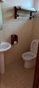 a bathroom with a white toilet and a sink at Paran Amboseli Resort in Kimana
