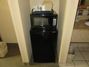 a microwave on top of a refrigerator in a room at La Hacienda Inn in San Antonio