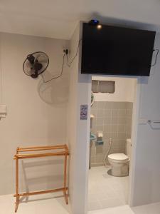 a bathroom with a toilet and a tv on the wall at QG restaurant and guesthouse in Hua Hin +15 photos