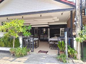 an outdoor patio with tables and chairs and plants at QG restaurant and guesthouse in Hua Hin
