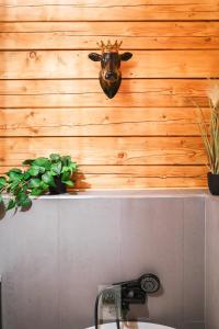 a bathroom with a cow head on a wooden wall at Leśne Zacisze Radawa I in Radawa