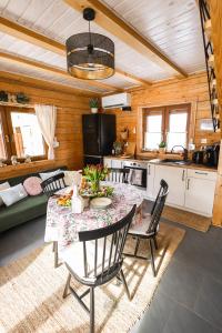 a kitchen and living room with a table and chairs at Leśne Zacisze Radawa I in Radawa