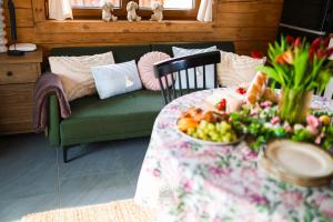 a green couch with a table with a bowl of fruit at Leśne Zacisze Radawa I in Radawa +37 photos