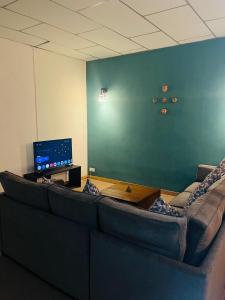 a living room with a couch and a television at Ceylon Airport Apartment in Raddoluwa