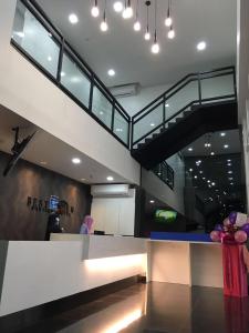 a lobby with a staircase in a building with people at NueVo Boutique Hotel, Kota Kemuning, Shah Alam in Shah Alam