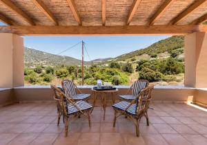 a patio with a table and chairs and a view at Seaside Aqua Bliss & Serenity with Private Pool in Kranidi