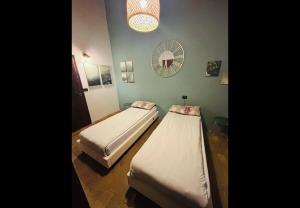 two beds in a room with a mirror at La locanda delle pulci in Colombella