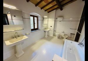 a bathroom with two sinks and a tub and a toilet at La locanda delle pulci in Colombella