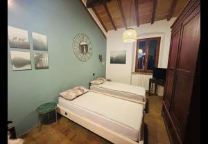 a room with two beds in a room with a mirror at La locanda delle pulci in Colombella +3 photos
