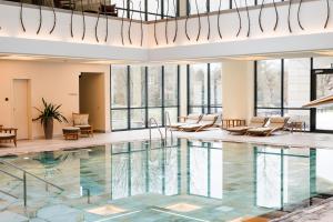a hotel lobby with a pool and chairs at Wald & Schlosshotel Friedrichsruhe in Friedrichsruhe