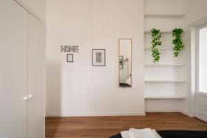a room with white walls and a mirror at Station 1 min - Monza Center, Milan - Wifi and AC in Monza +37 photos