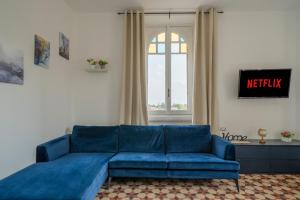 a blue couch in a living room with a window at Station 1 min - Monza Center, Milan - Wifi and AC in Monza