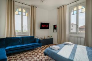 a living room with a blue couch and a bed at Station 1 min - Monza Center, Milan - Wifi and AC in Monza