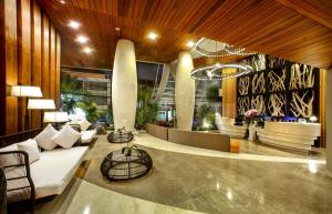 a lobby of a hotel with a couch and chairs at Bedrock Hotel Kuta in Kuta
