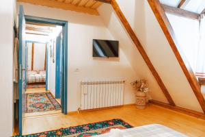 ein Zimmer mit einem Bett und einem Fernseher an der Wand in der Unterkunft Casa Grosu in Preluca