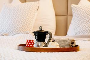 a coffee pot and ice cream on a tray on a bed at Brána historic Boutique Apartments in Horažďovice