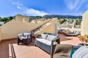 a balcony with chairs and a view of a city at Bungalow Montesol con Vistas al Mar y Montaña in Calpe