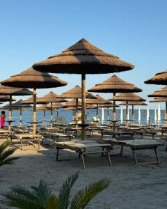 a group of tables and umbrellas on a beach at Appartamenti Eco del Mare in Lido di Pomposa