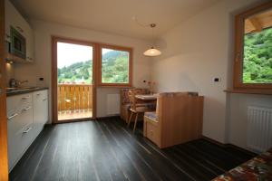 a kitchen and dining room with a table and a window at Residence Rosengarten - Alpenglühen zum Anfassen, inklusive Guestpass in Tires